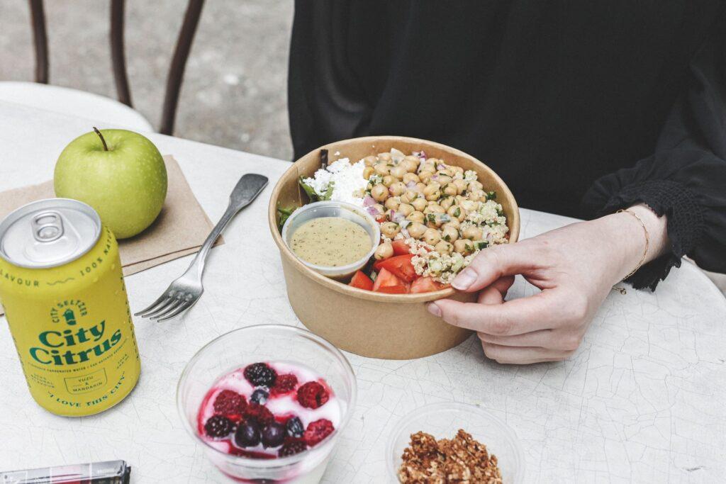 A customer enjoys a take out salad bowl