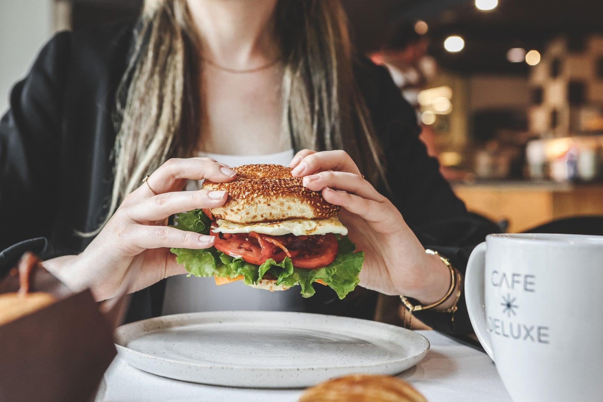 A customer eats a bagel