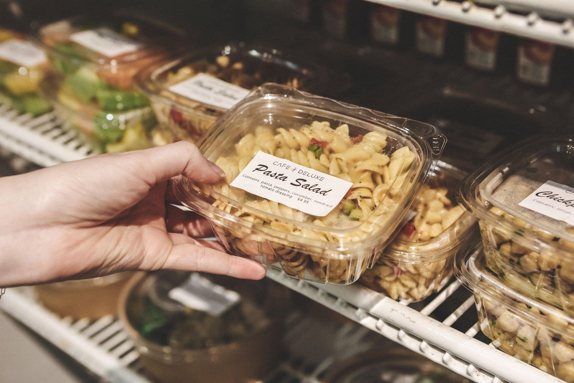 A customer picks out a pasta salad